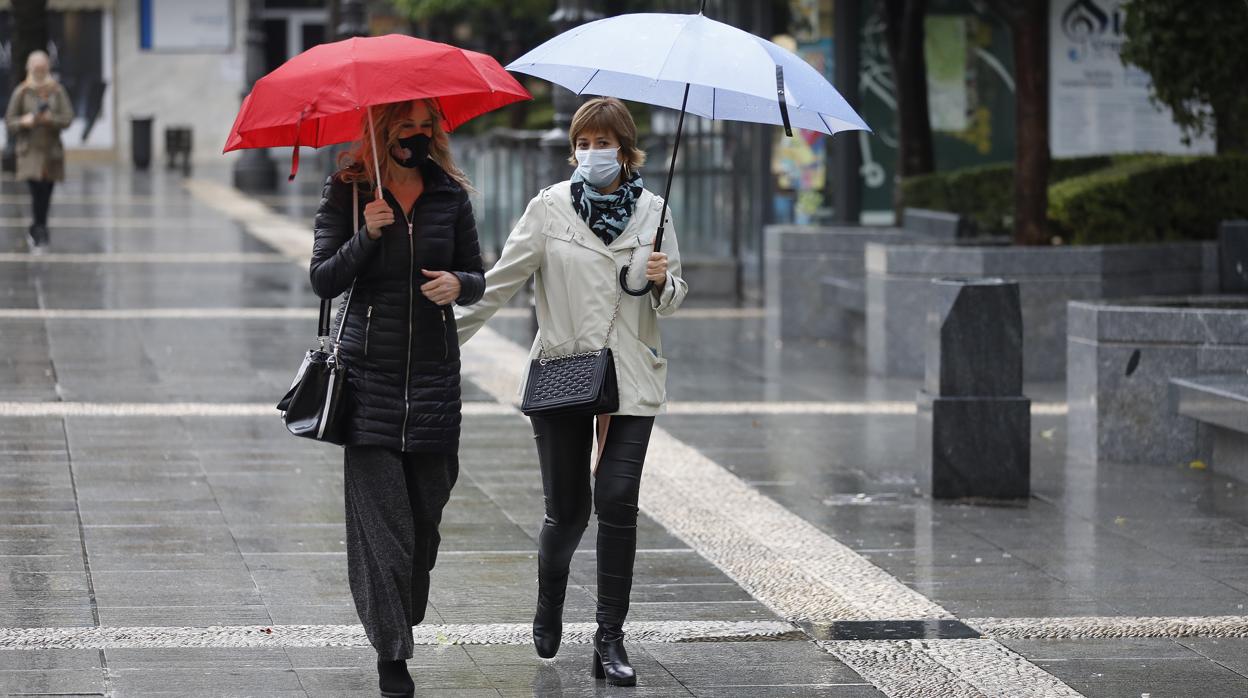 Dos mujeres pasan por la plaza de las Tendillas, en una reciente jornada de lluvias en Córdoba