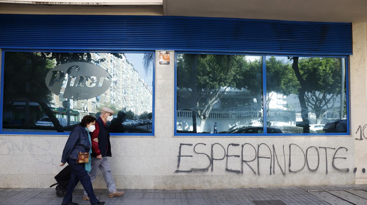 Una pareja pasa delante de las instalaciones del laboratio Pfizer en Málaga