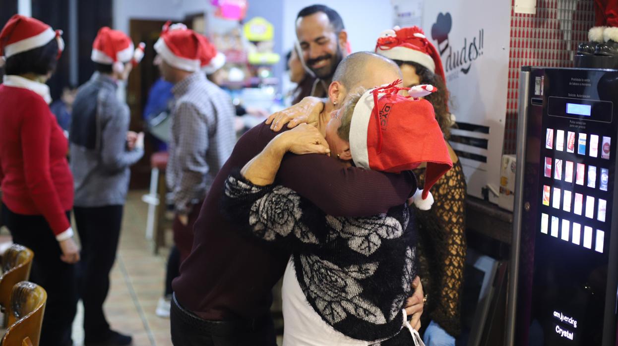 Un joven abraza a una mujer en una cena de Nochebuena