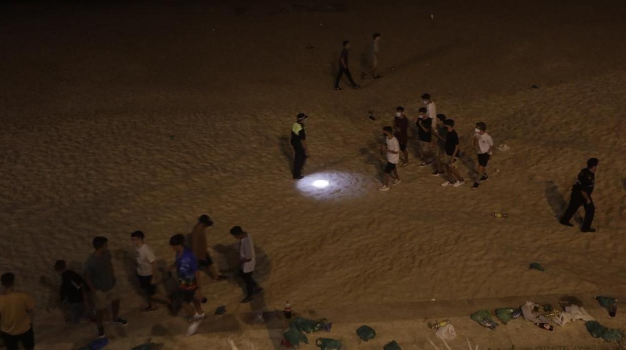 Jóvenes en una playa de botellón