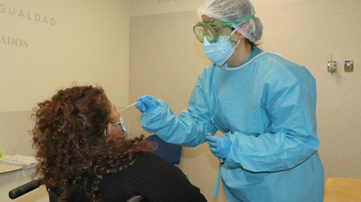 Un sanitario toma muestras de una paciente para una prueba diagnóstica de coronavirus