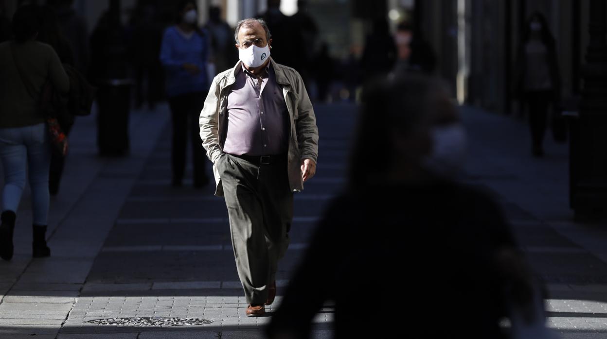 Un hombre pasea por el Centro de Córdoba bajo el sol otoñal