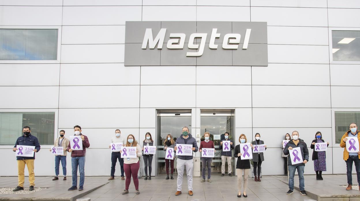 Trabajadores de Magtel en la sede de la empresa con pancartas con lazos violetas