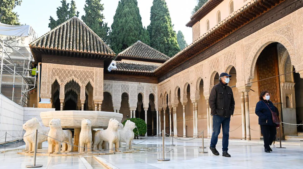 Dos personas caminan por el Patio de Leones de la Alhambra, históricamente el monumento más visitado de España y uno de sus iconos turísticos el martes 1 de diciembre