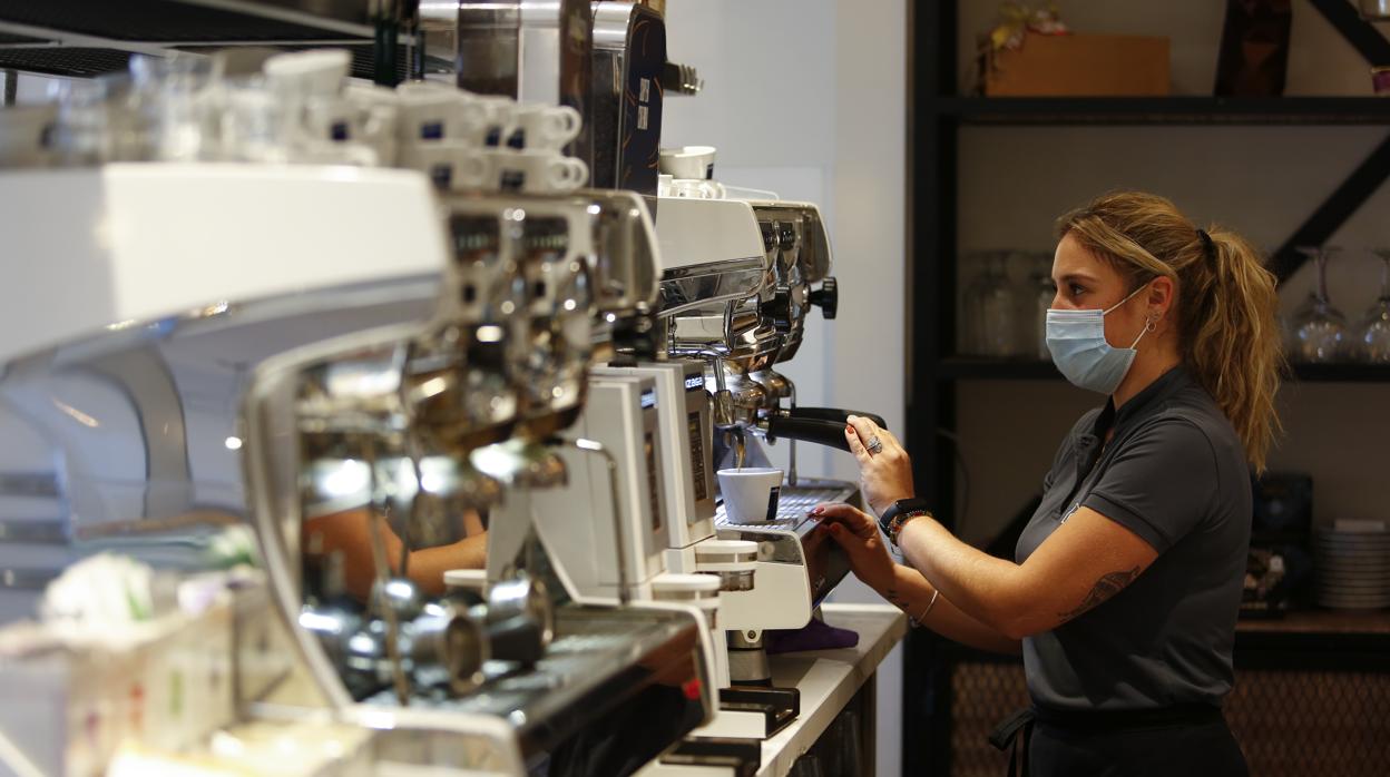 Una camarera sirviendo café en un bar de Granada tras levantar las restricciones