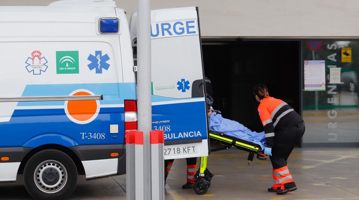 Dos personas bajan a un enfermo en las puertas del hospital Reina Sofía de Córdoba