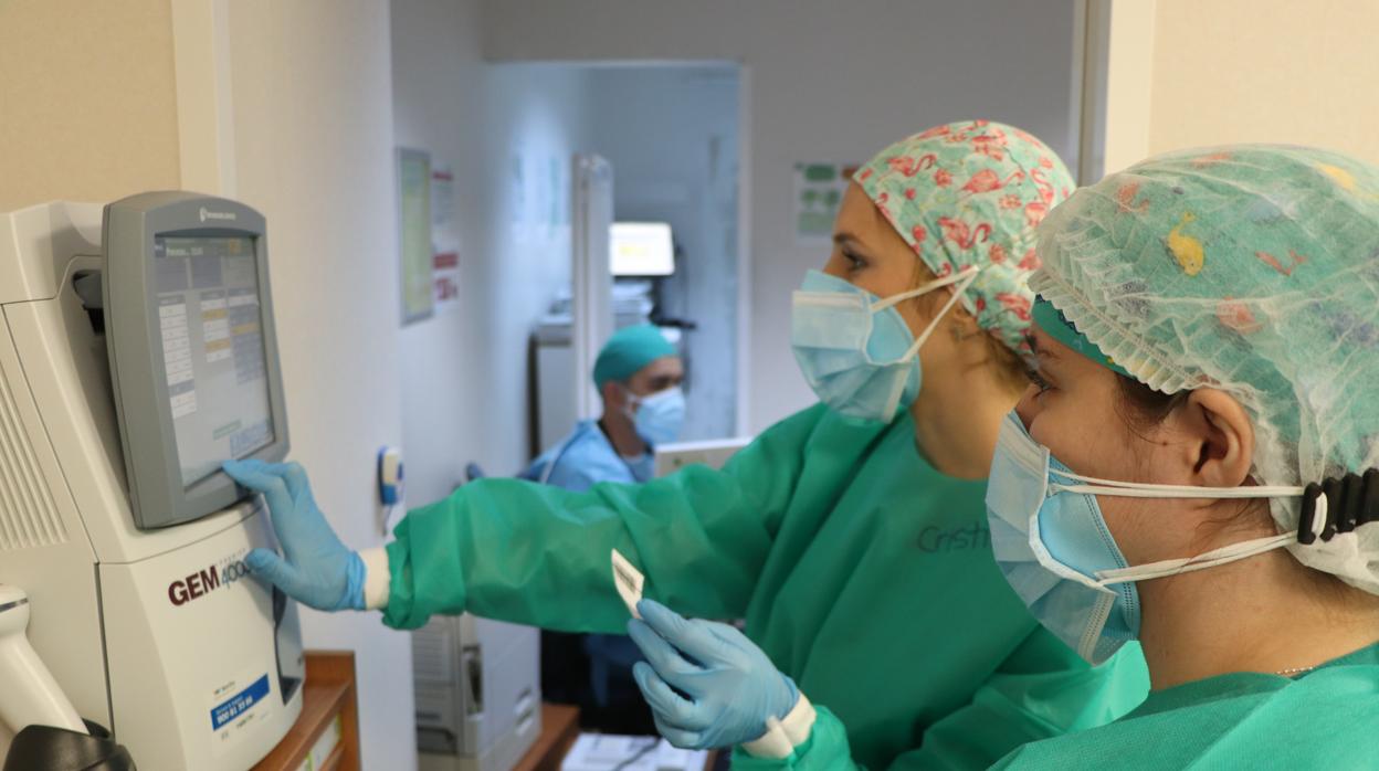 Dos sanitaras en la Unidad de Cuidados Intensivos del Hospital Reina Sofía de Córdoba