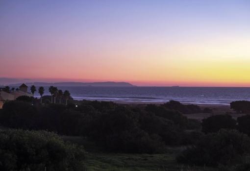 Desde la playa de Atlanterra se divisa el litoral marroquí, como se aprecia en el horizonte de este anochecer