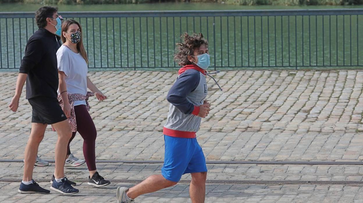 Un hombre corre por el río con la mascarilla, obligatoria para hacer deporte por el Covid