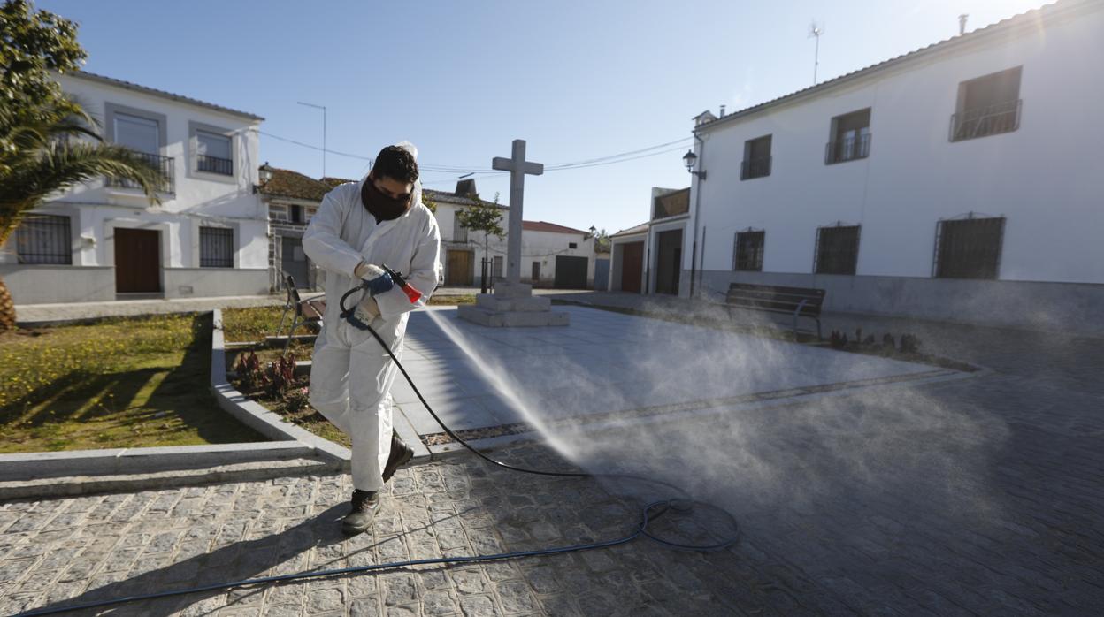 Un operario desinfecta este lunes una calle de Añora, confinada en su totalidad por la alta incidencia