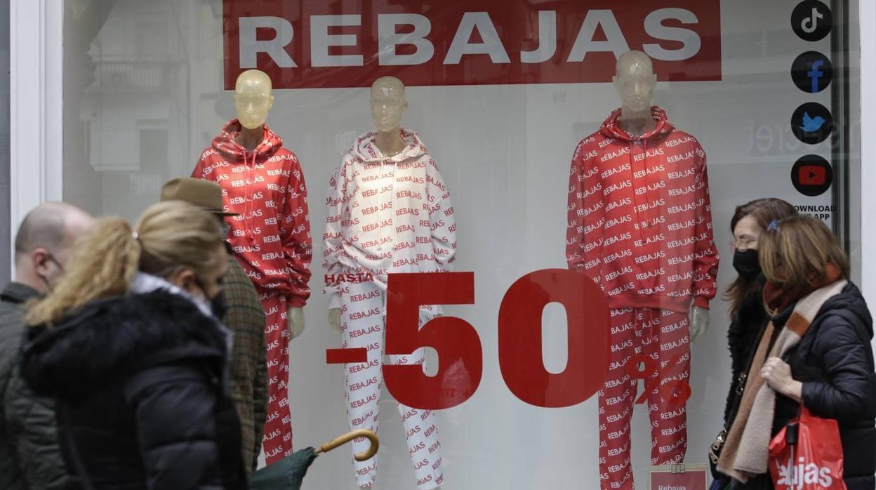 Varias personas pasean por la puerta de un comercio de Andalucía en plena época de rebajas