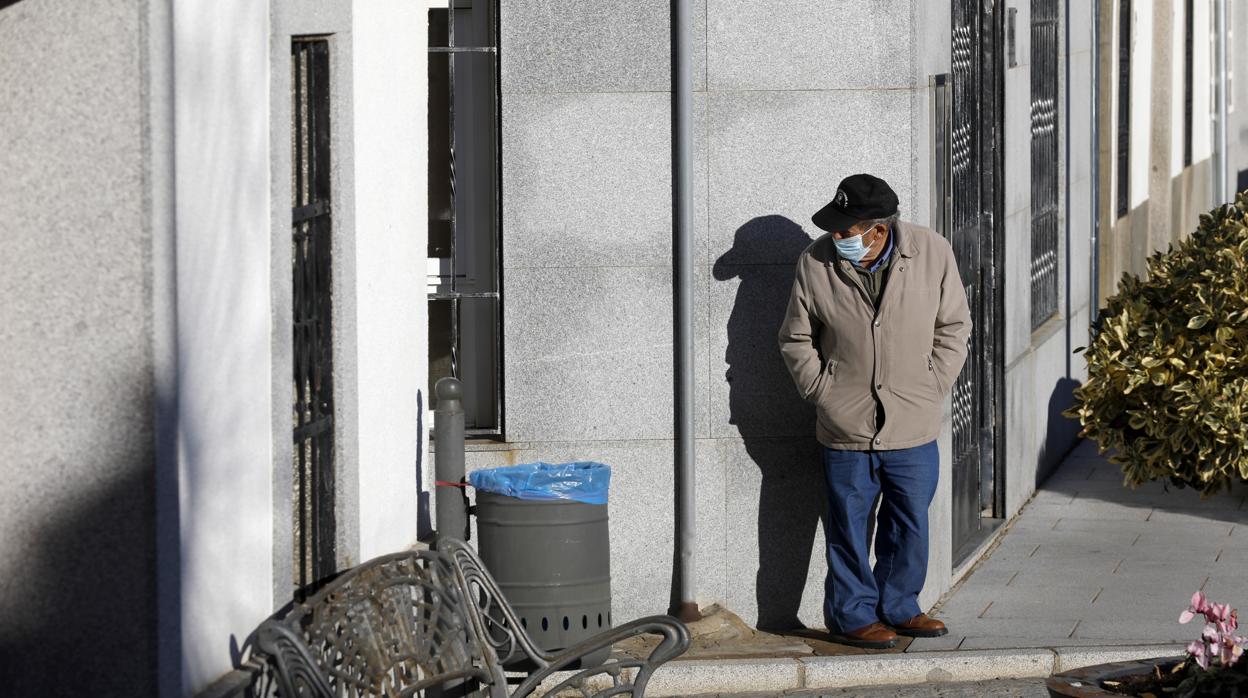 Un hombre con mascarilla en una esquina de una calle solitaria de Añora esta semana