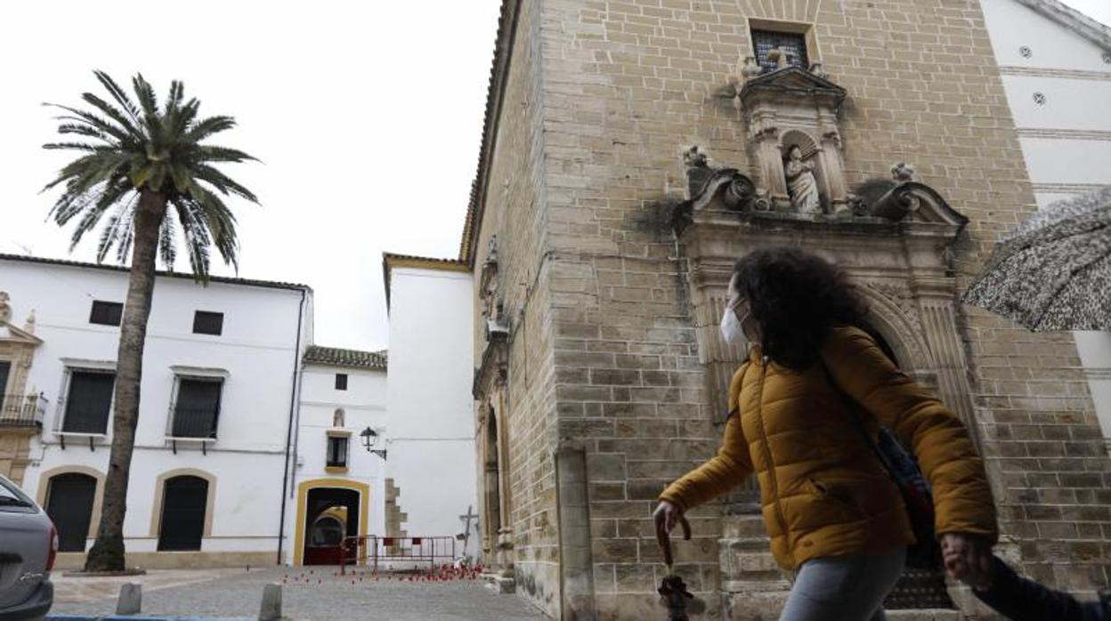 Una mujer pasa por delante del convento en cuya puerta estaba la cruz