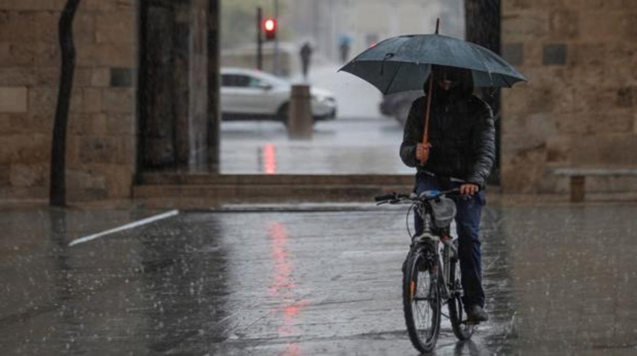 Un joven protegiéndose de la lluvia en una imagen de archivo