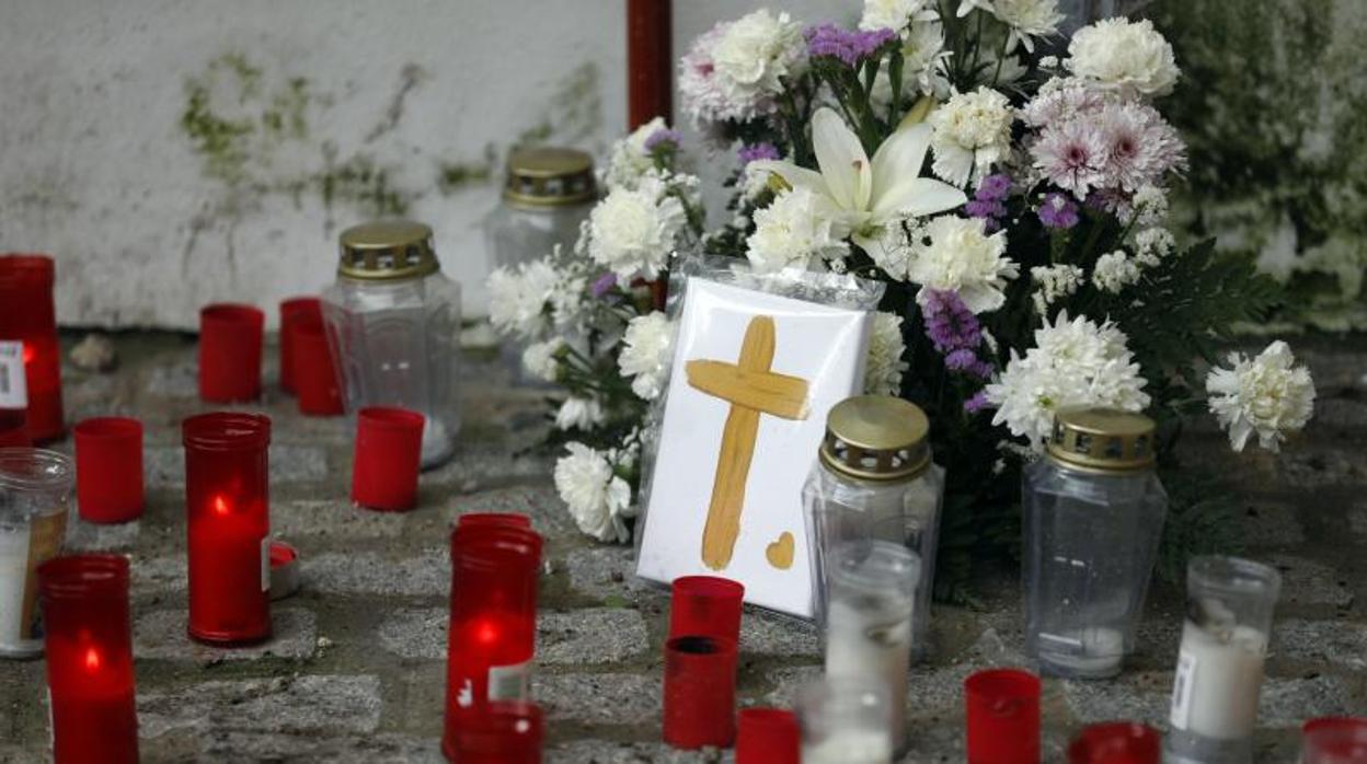 Velas y flores en el lugar en el que estaba la cruz