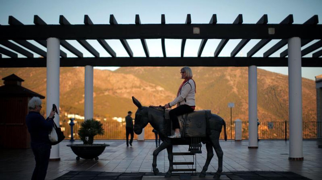 Una turista, subida a la famosa escultura en homenaje al burro de Mijas