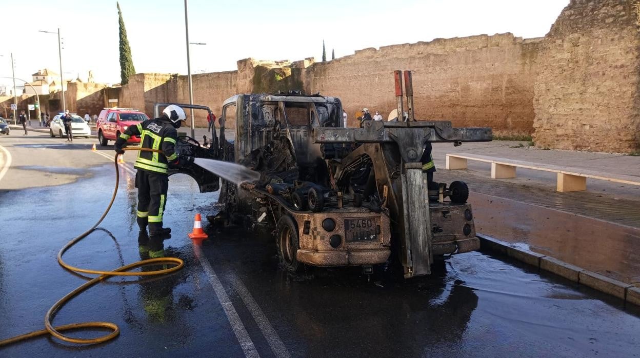 Un bombero apaga los restos de las llamas