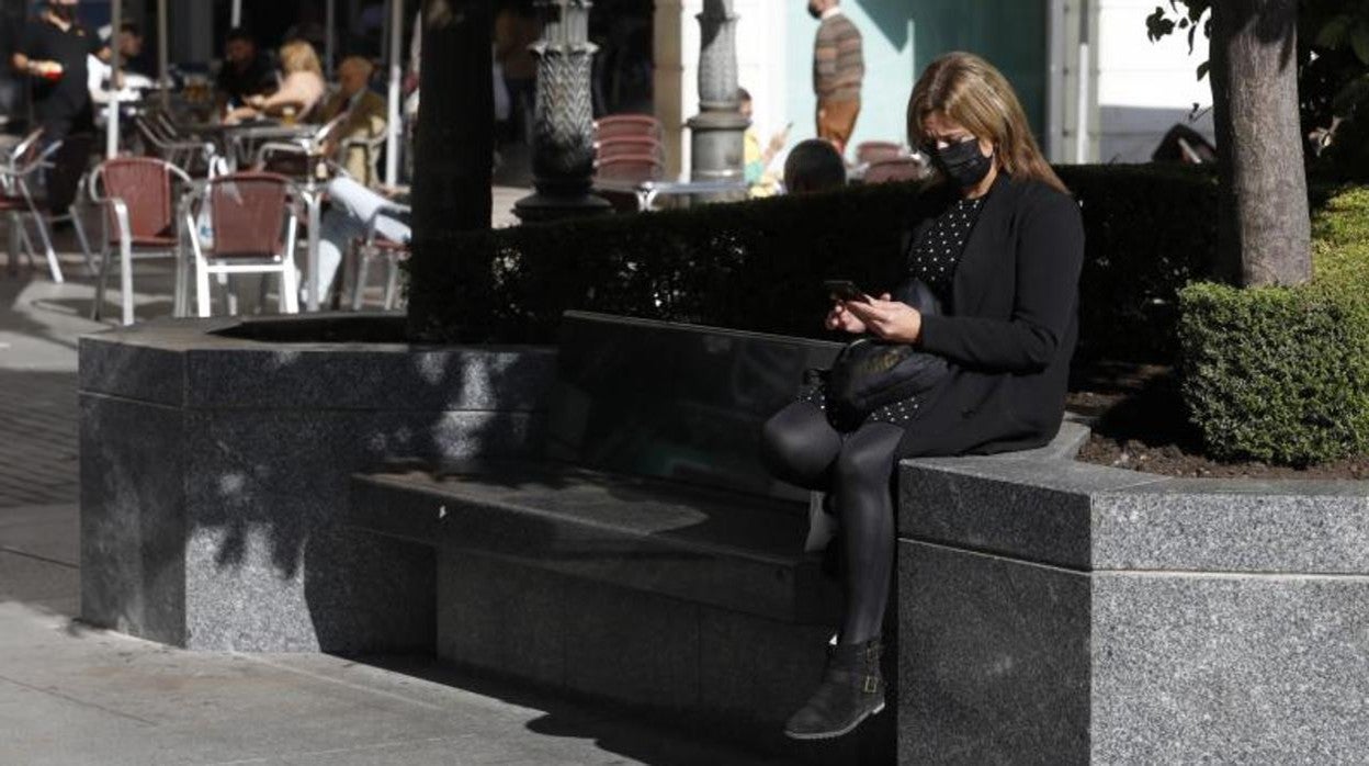 Una joven, sentada en los bancos de Las Tendillas