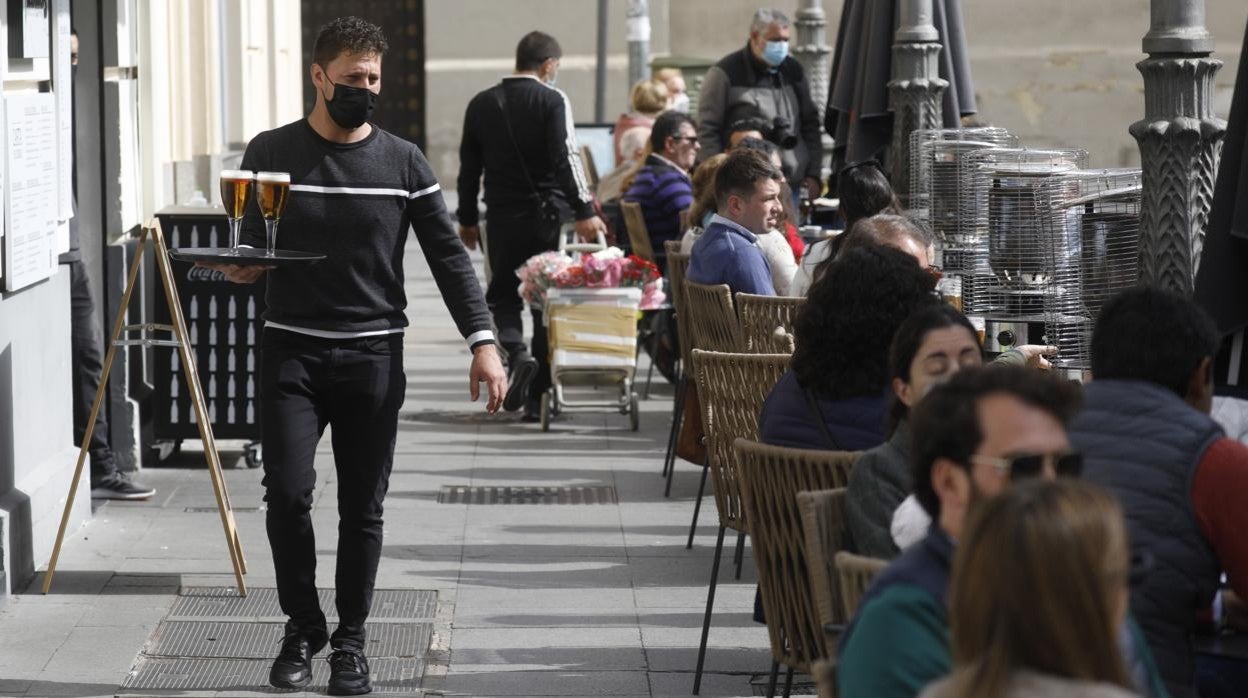 Un camarero atiende a los clientes de una terraza en Córdoba