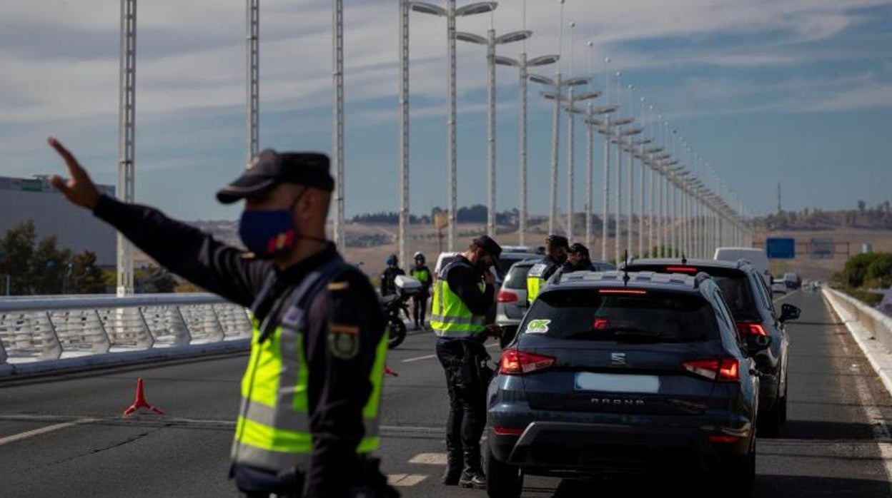 Agentes del Cuerpo Nacional de Policía realizan hoy controles de movilidad a conductores en la salida de Sevilla capital a la altura del Puente del Alamillo