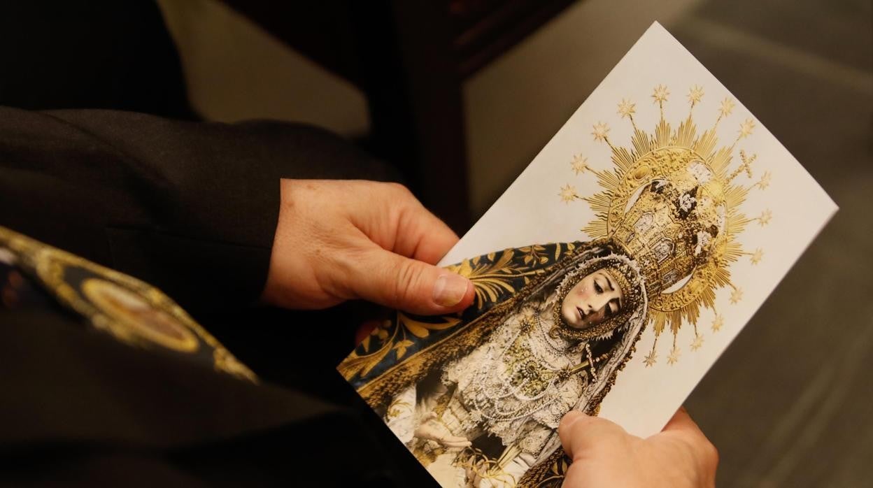 Una mujer sostiene una estampa de la Virgen, el Viernes de Dolores de 2019