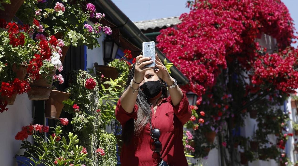 Una mujer saca una fotografía en el patio de Marroquiés, 6
