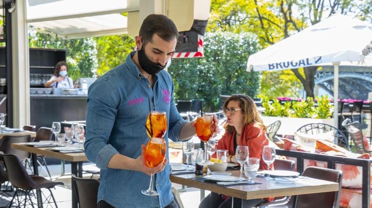 Un camarero sirve unas bebidas en un bar