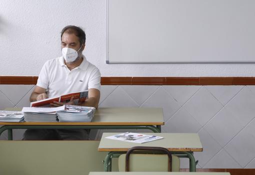 Un docente consulta un libro de texto