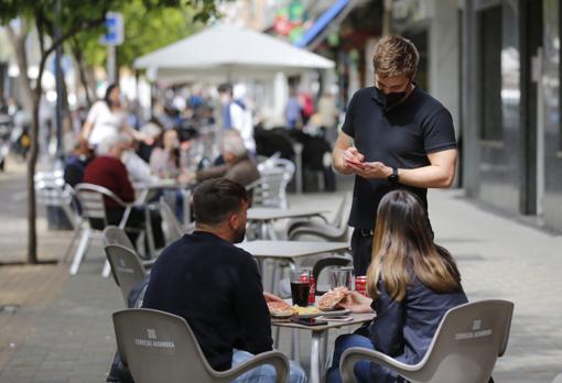 Un camarero atiende a una pareja en la avenida de Barcelona