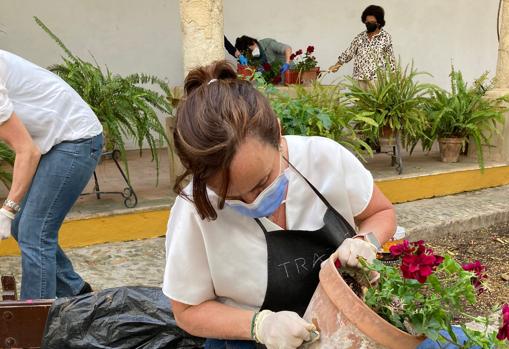 Una voluntaria prepara una maceta en el patio de entrada del convento