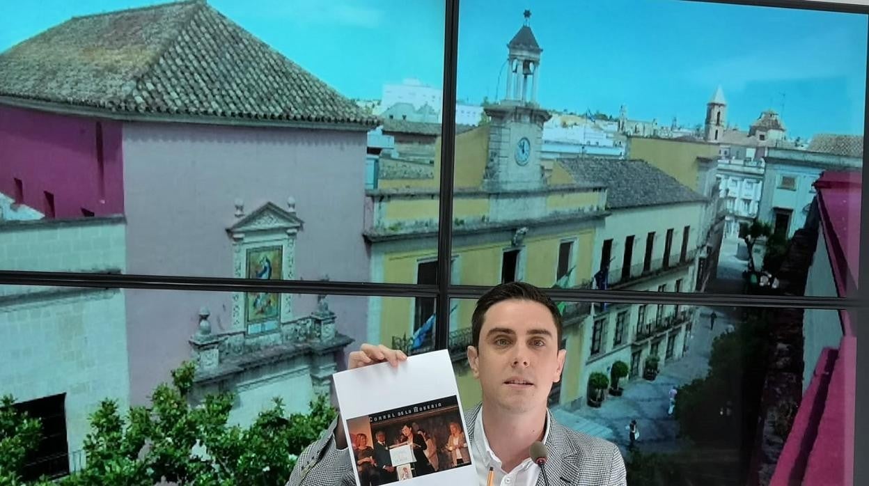 El edil del PP mostrando la foto de Mamen Sánchez con la presidenta de la firma