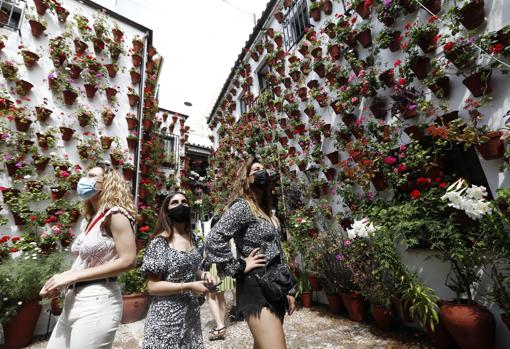 Tres jóvenes observan un patio de San Basilio