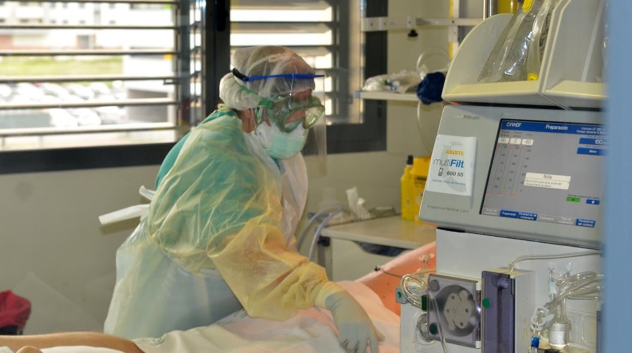 Una sanitaria atiende en la UCI del Hospital Reina Sofía de Córdoba a un paciente Covid