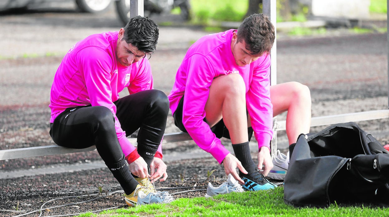 El capitán del Córdoba, Javi Flores, se ata los cordones de la botas junto a Del Moral