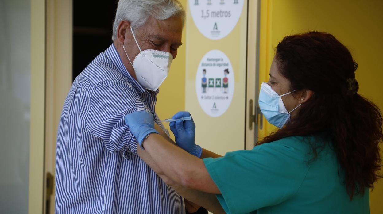 Una sanitaria pone una vacuna a un ciudadano en Córdoba