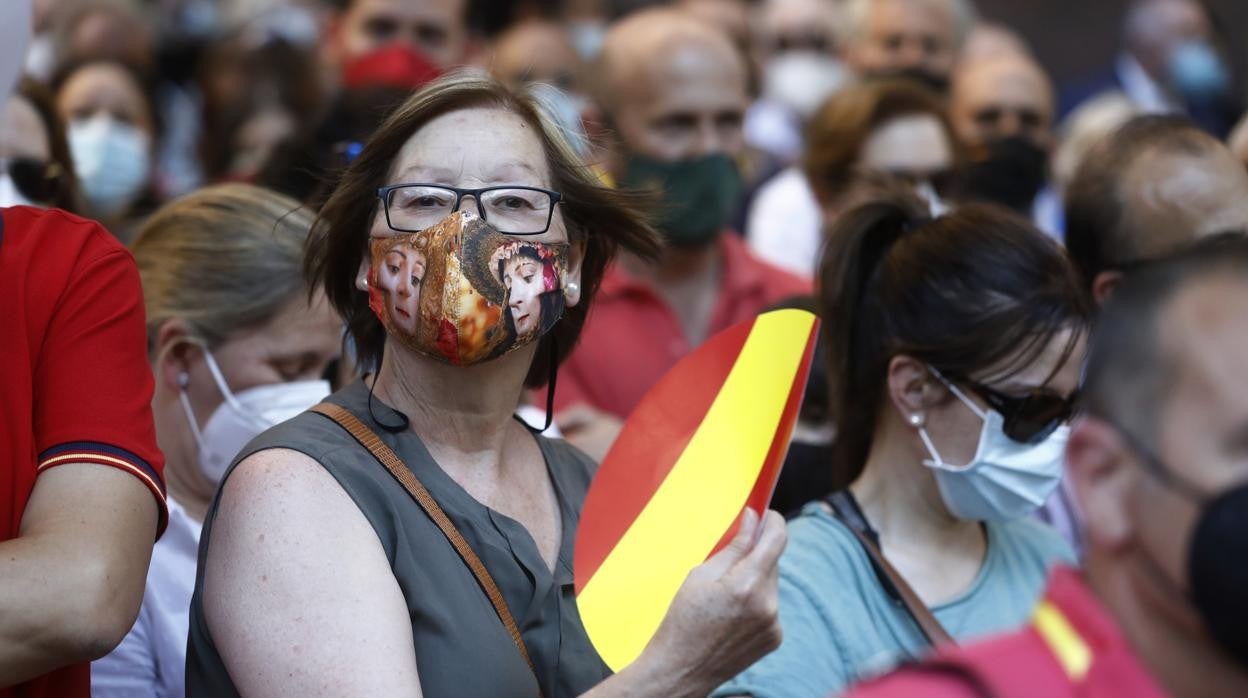 Una mujer, con mascarilla y abanico, en un acto público este miércoles en Córdoba