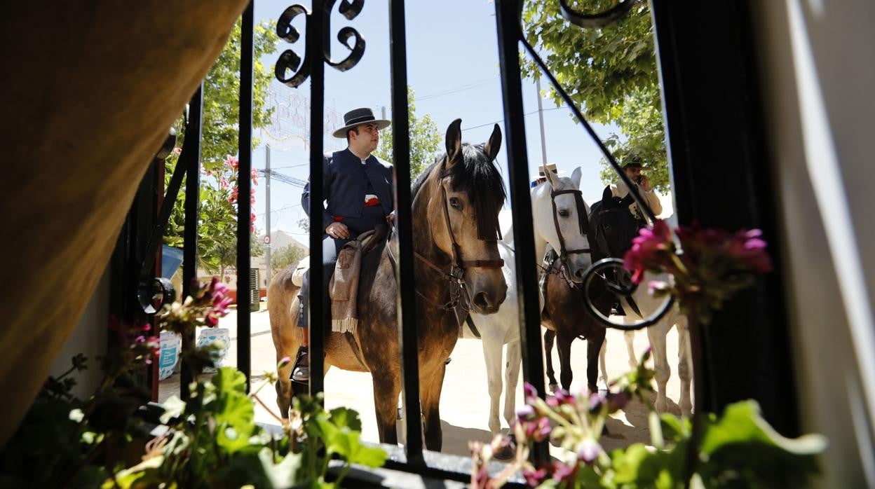 Dos caballistas vistos a través de la ventana de una caseta de la Feria de Córdoba