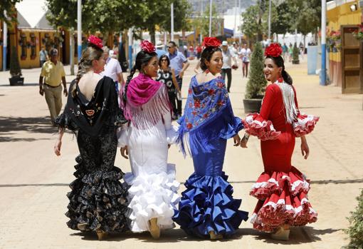 Cuatro jóvenes vestidas de flamenca en la Feria de Córdoba