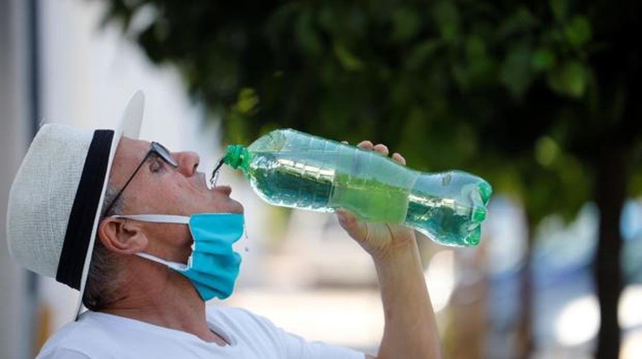 Un hombre se refresca en la calle