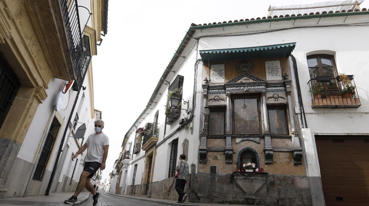 Dos personas cerca del retablo de la esquina de Lineros con Candelaria