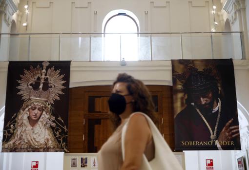 Una mujer pasa ante dos grandes fotografías de los titulares de la Quinta Angustia