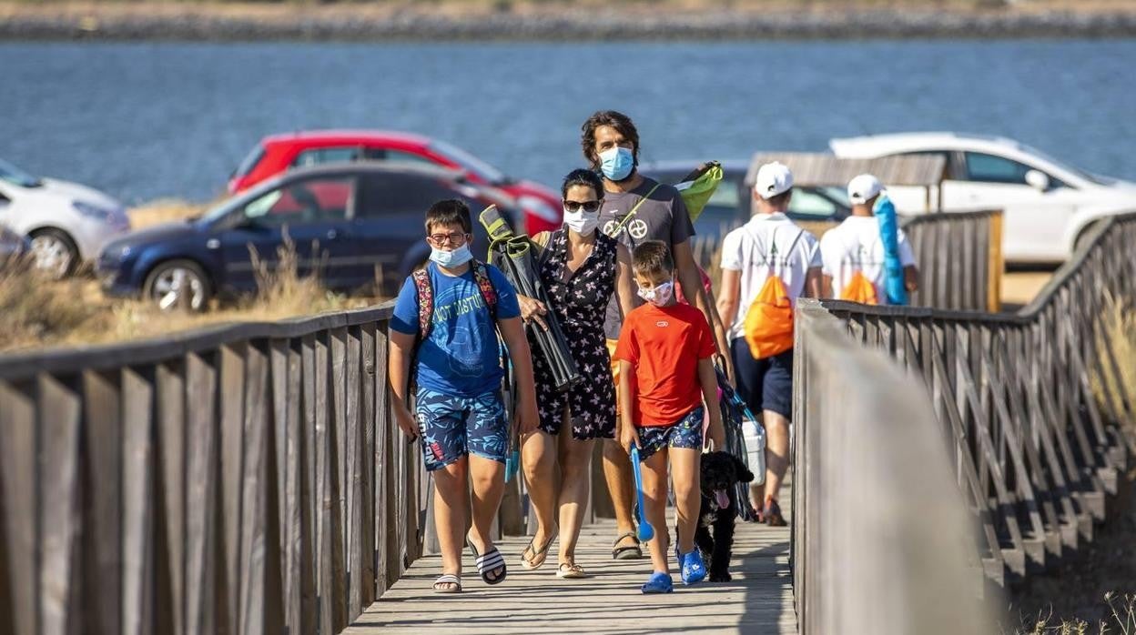 Familia llegando a la playa con mascarilla puesta