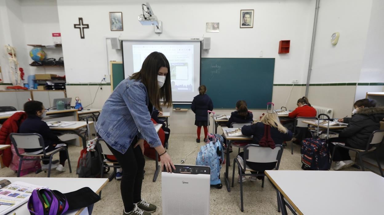 Una profesora coloca un purificador de aire en un aula del colegio de los Salesianos de Córdoba