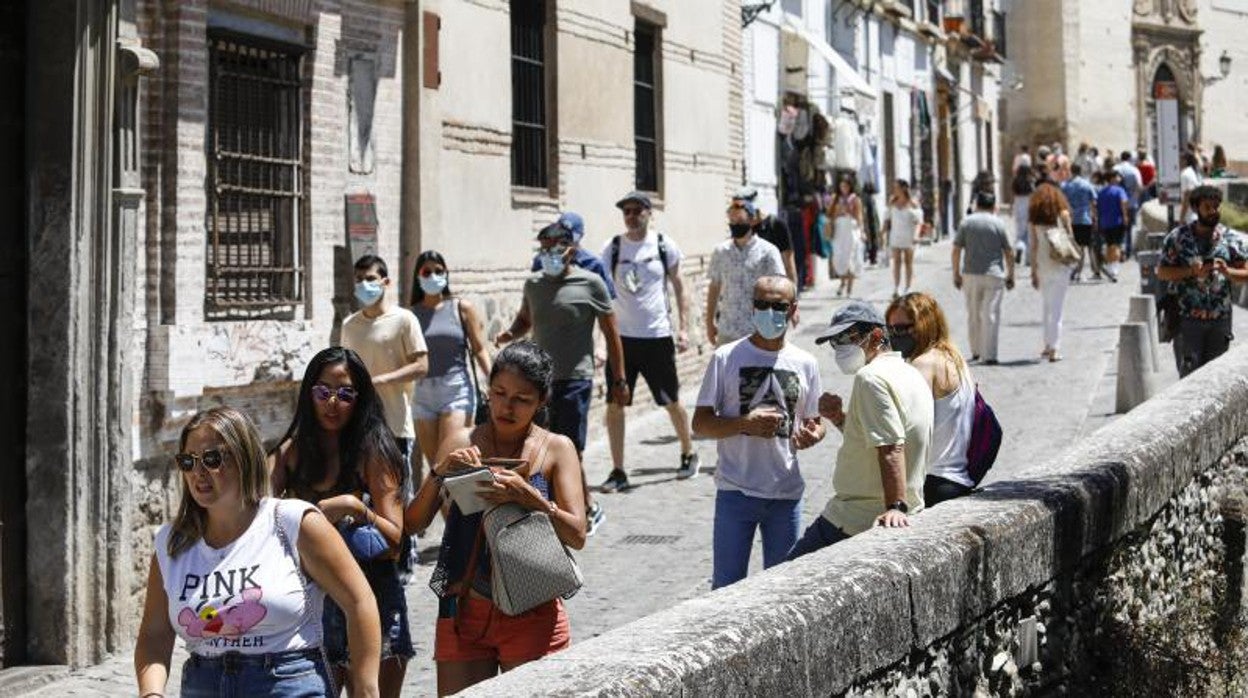 Turistas con y sin mascarillas en Granada