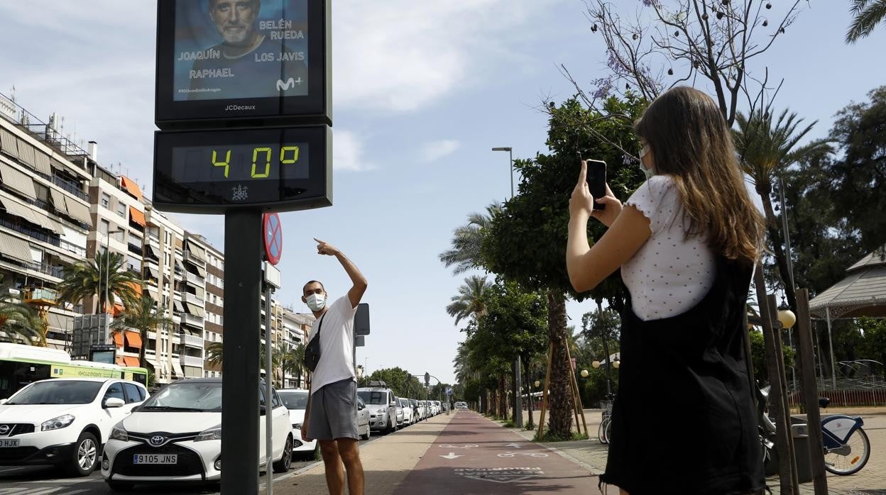 Un joven señala un termómetro callejero a 40 grados en Córdoba