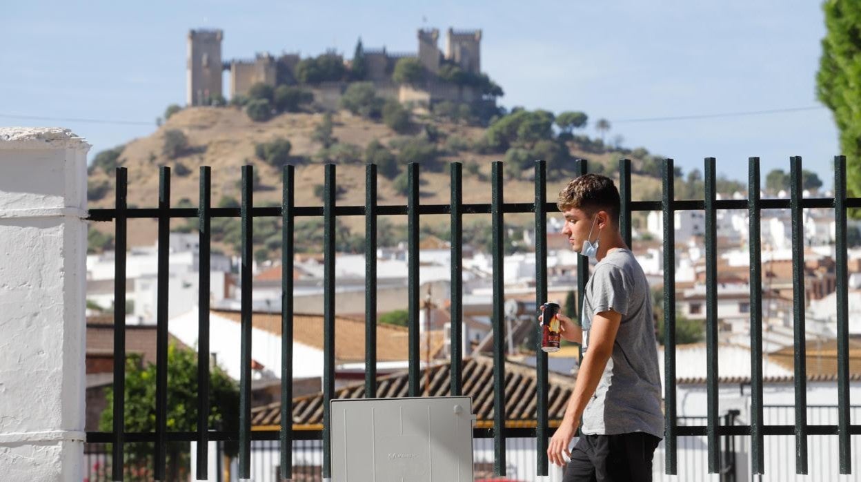 Ubn joven pasea por Almodóvar del Río con el castillo al fondo, una localidad donde están repuntando los casos