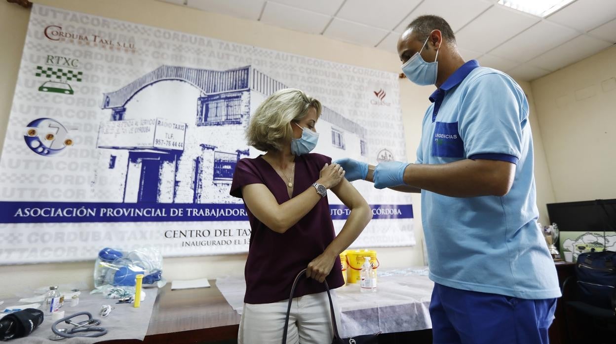 Un sanitario vacuna a una mujer en la sede de la Asociación de Autónomos del Taxi de Córdoba