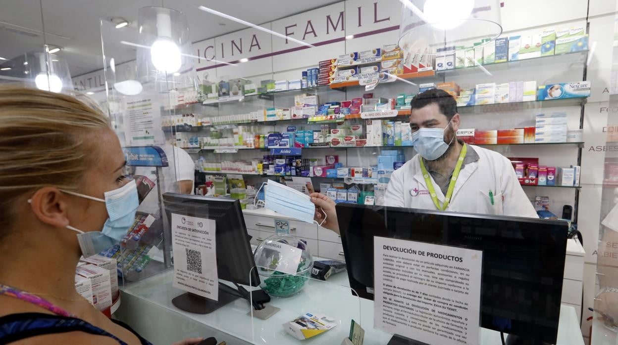 Una usuaria compra mascarillas en una farmacía de Córdoba durante la pandemia