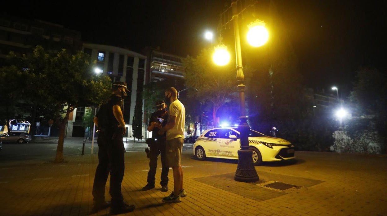 Dos agentes con un joven en el centro de la ciudad