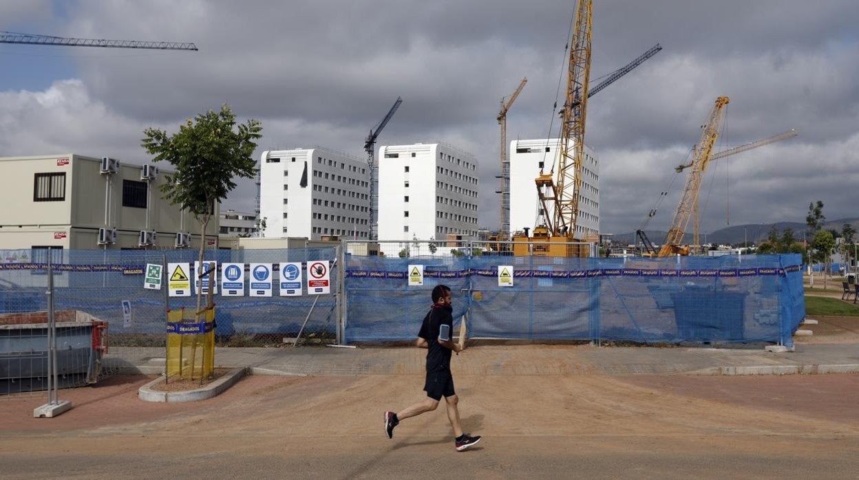 Un hombre pasa corriendo delante de las promociones en construcción en Chinales